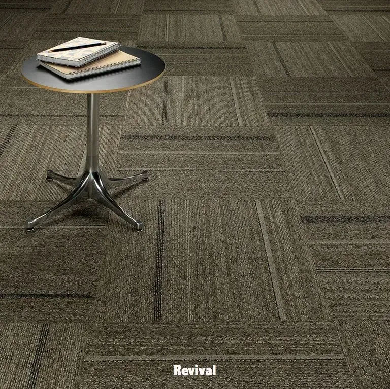Small round table with books on a patterned carpeted floor. Carpet is textured with light and dark brown tones.