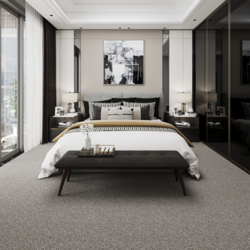 Elegant bedroom with large bed, bench, artwork, dark wood furniture, and gray carpet.