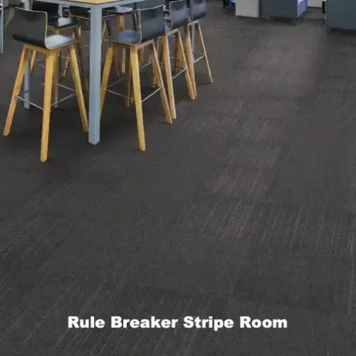 Dark room with a table, bar stools, and carpet labeled “Rule Breaker Stripe Room.”