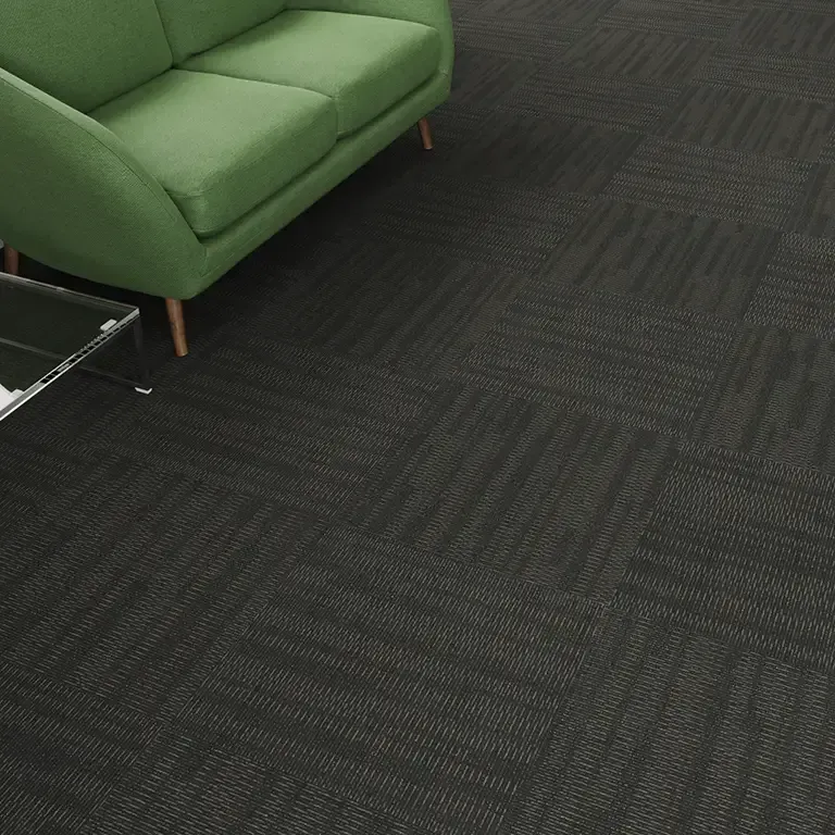 Green sofa on dark patterned carpet; corner view.