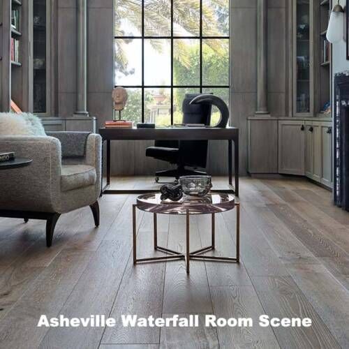 A room scene featuring wood flooring and a desk with a window, a chair, and a loveseat.