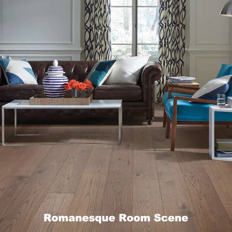 Living room with hardwood floors, brown leather sofa, blue chairs, patterned curtains, and a white coffee table.