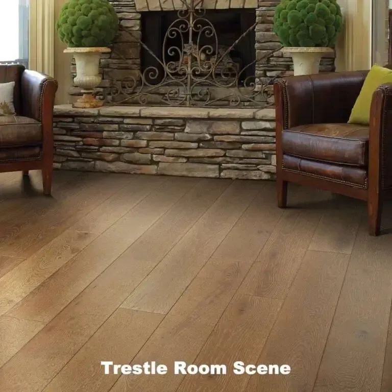 Hardwood floor in front of a stone fireplace with two leather armchairs.