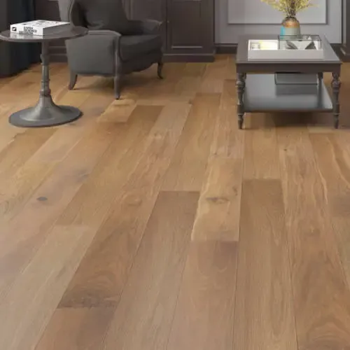 Hardwood floor in a living room with furniture. Wooden floors are light brown.