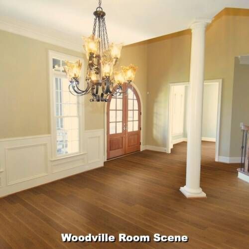 Empty dining room with chandelier, wooden floors, and beige walls.
