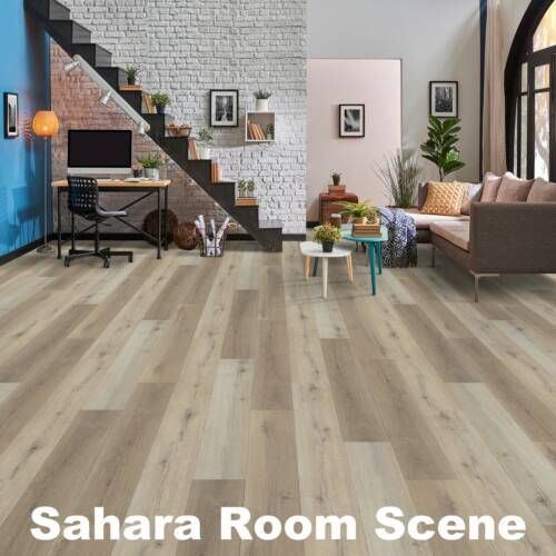 Living room with light wood floors, a staircase, and a desk. The room has neutral colors with some pops of blue.