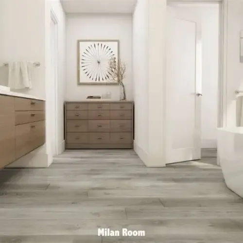 Bathroom with wooden floors, neutral walls, wooden dresser, art, and a partially visible tub.