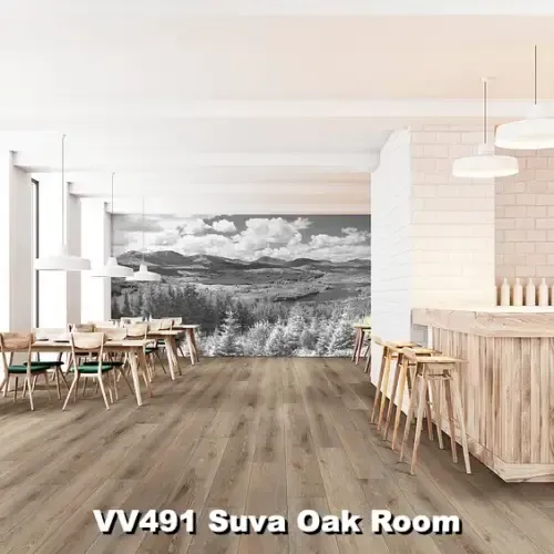 A bright, modern room with light oak flooring, tables, chairs, and a bar. A black-and-white landscape mural is on the wall.