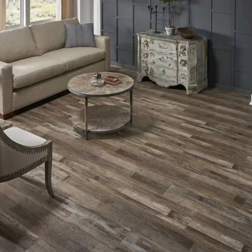 Living room with wooden floors, sofa, chair, and coffee table.