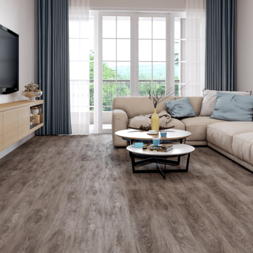Living room with wood floors, a beige sectional sofa, and a large window with blue curtains.