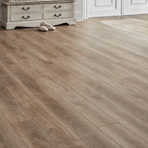 Wooden floorboards in a room with a white cabinet and pair of ballet flats.