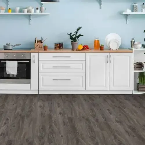 Kitchen with white cabinets, wooden countertop, and grey wood-look flooring. Blue wall, shelves with dishes.