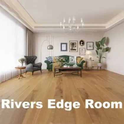 Rivers Edge Room: Interior view of a living room with wooden floors, sofa, armchair, and decorative elements.