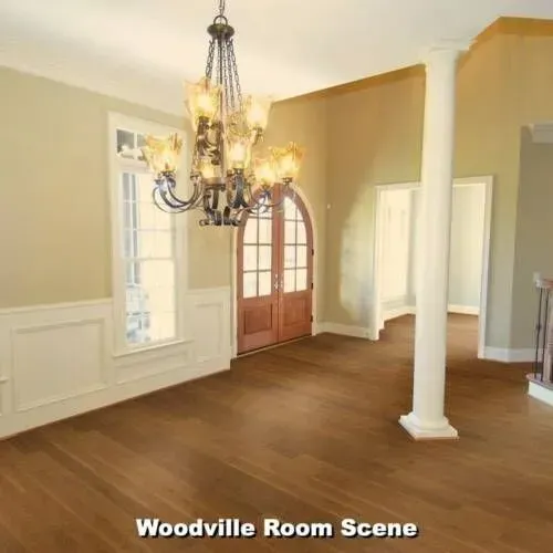 Empty dining room with chandelier, wooden floors, and beige walls.