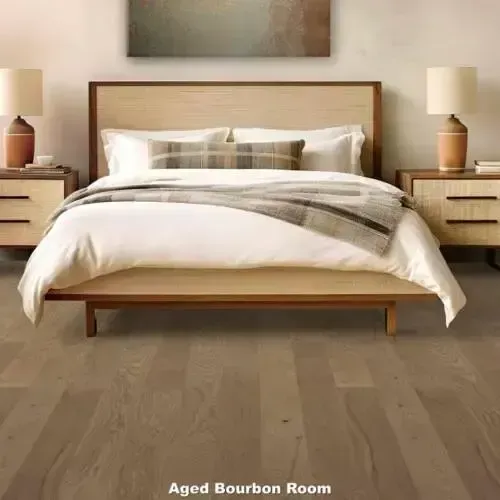 Bedroom with light-colored wood furniture, bed with white bedding, and hardwood floors.