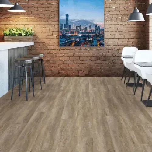 A cafe interior with wood floors, brick walls, and a bar with stools. Cityscape art hangs on the wall.