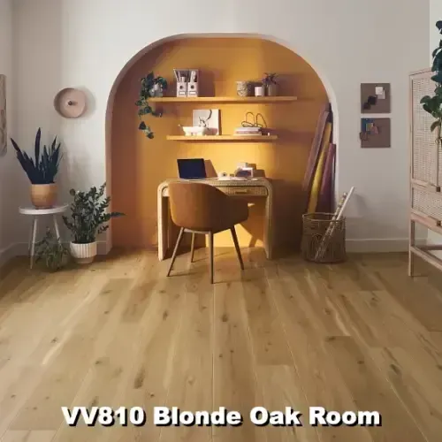 Room with blonde oak flooring, desk in a mustard-yellow alcove, shelves with décor, and plants.