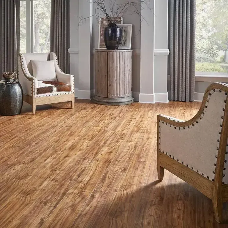 Living room with wood flooring, two chairs, curtains, and a decorative pedestal.