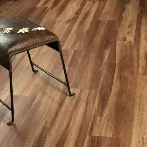 Brown stool on wood-look floor with some floral decor on the stool's seat.