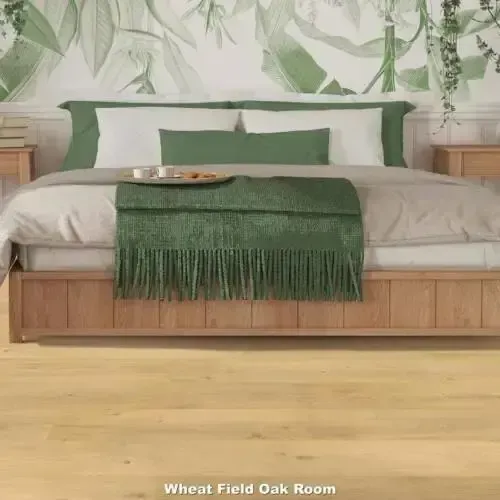 Bedroom with wooden bed frame, green bedding, and light oak floor.