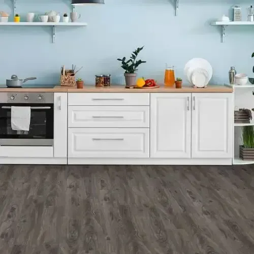 Kitchen with white cabinets, wooden countertop, and grey wood-look flooring. Blue wall, shelves with dishes.