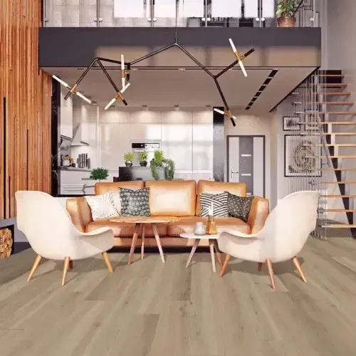 Living room with light-colored flooring, brown leather sofa, white chairs, and loft with stairs.
