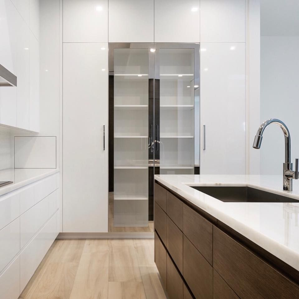 Modern kitchen with white cabinets, island, and built-in pantry