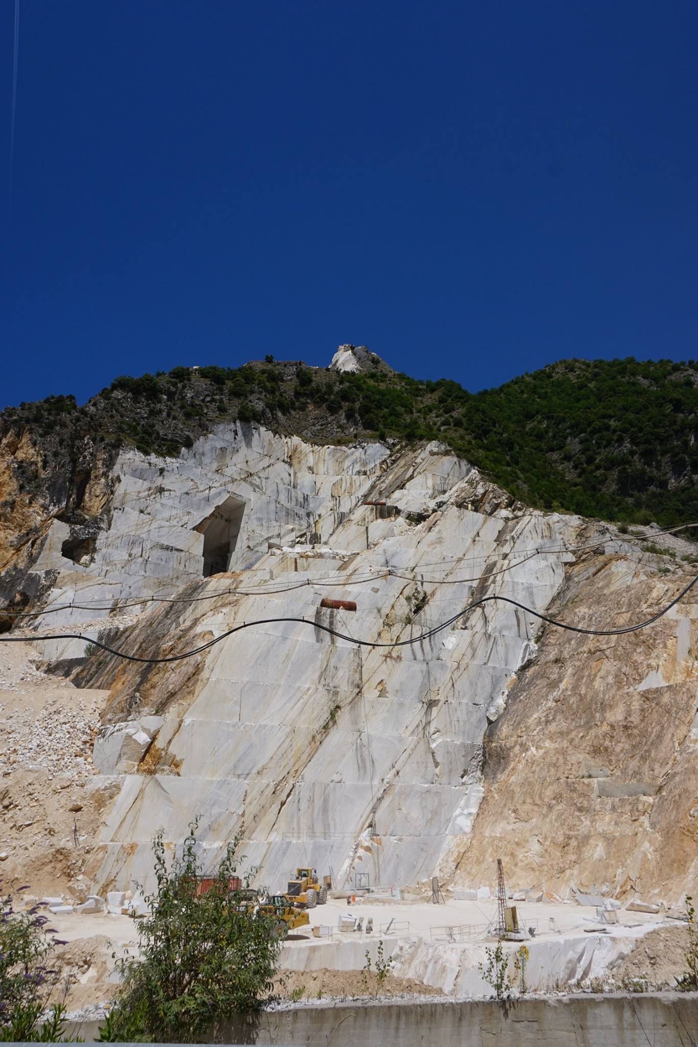 Marble quarry carved into a hillside with blue sky above
