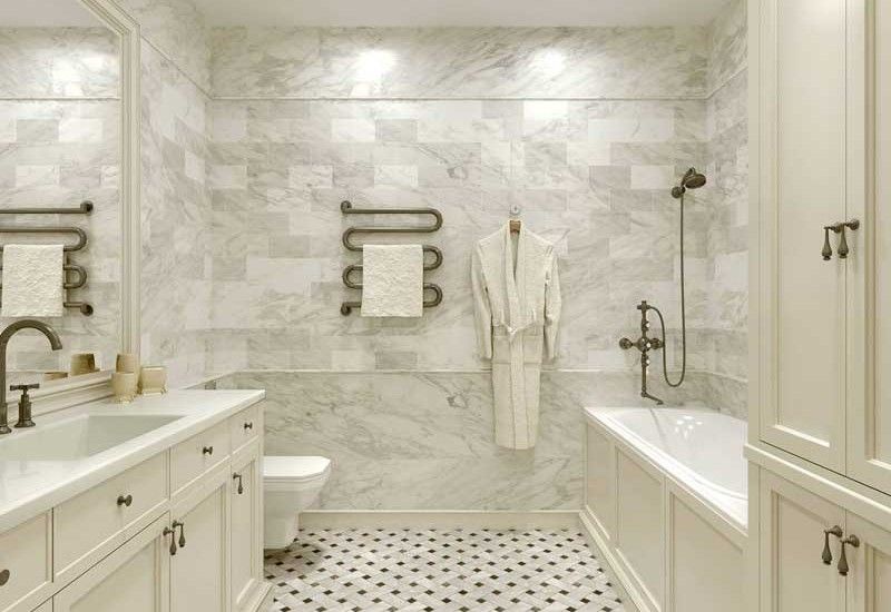 Elegant white marble bathroom with vanity, tub, and patterned floor