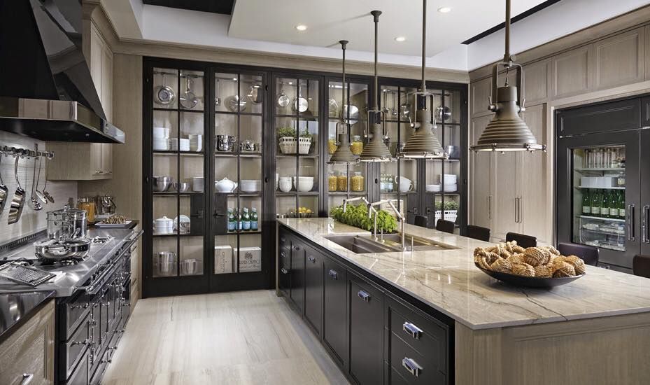 Elegant kitchen with large island, black cabinetry, glass-front cabinets, and pendant lights