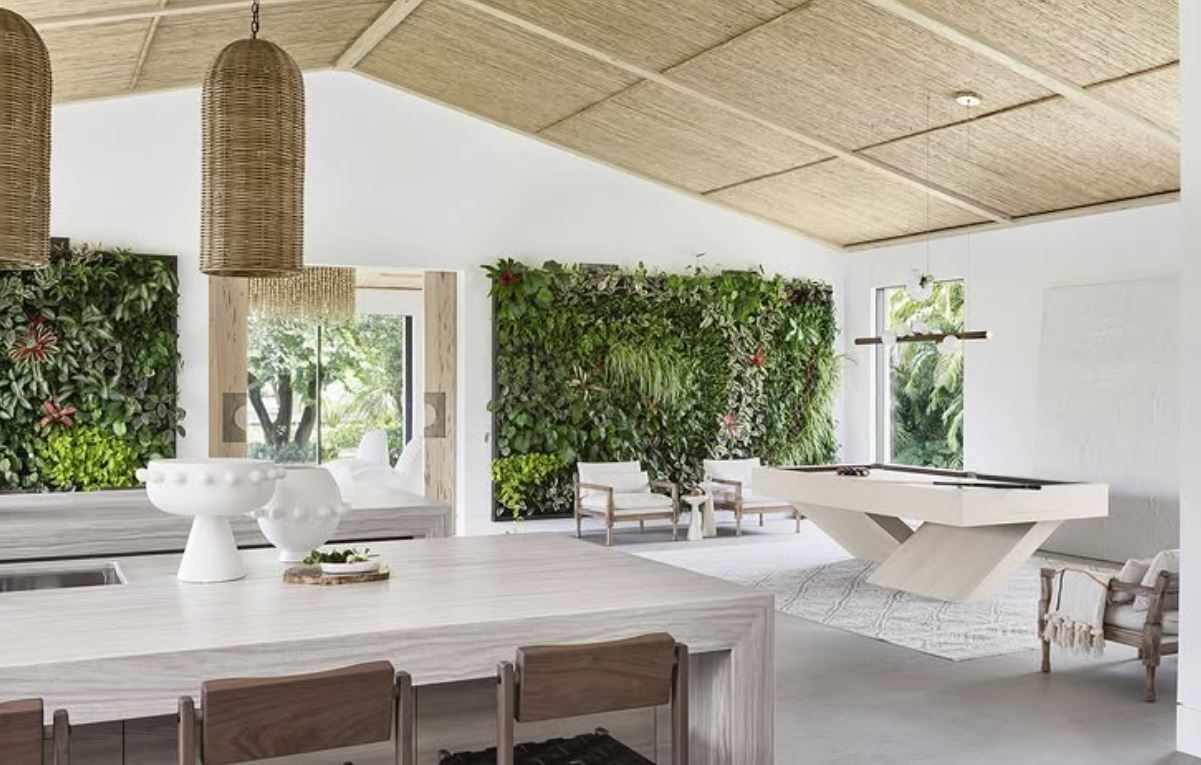 Spacious white interior with green wall and geometric pool table, natural wood ceiling and pendant lights
