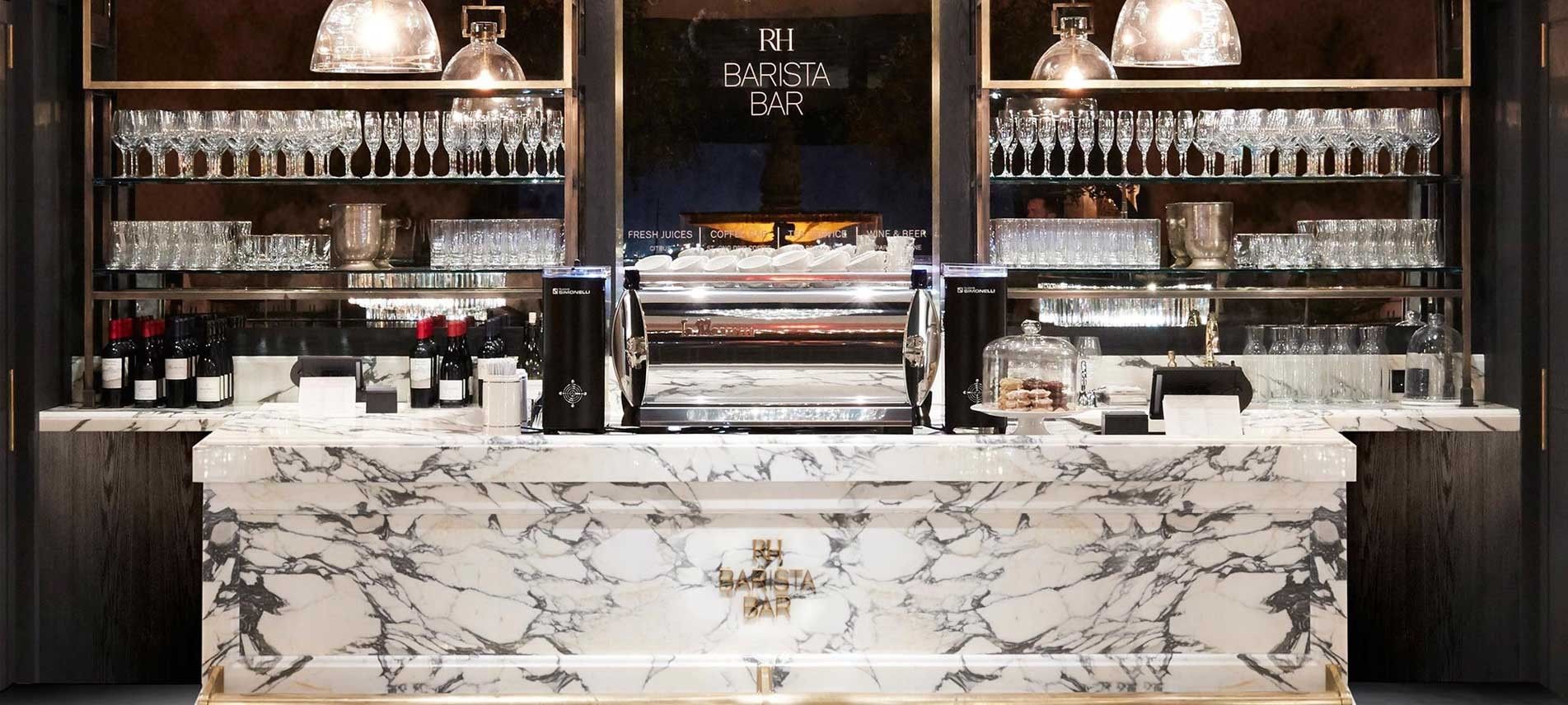 Marble bar in a cafe with glassware, bottles, and an espresso machine