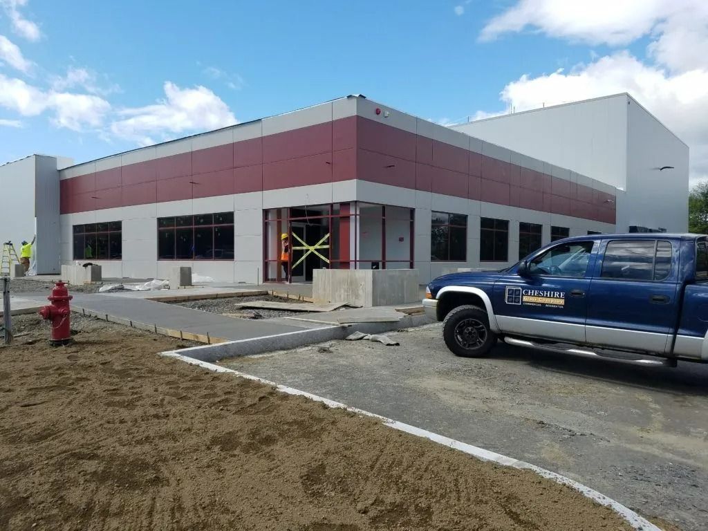 Commercial building under construction with a blue pickup truck parked outside and a fire hydrant in front.