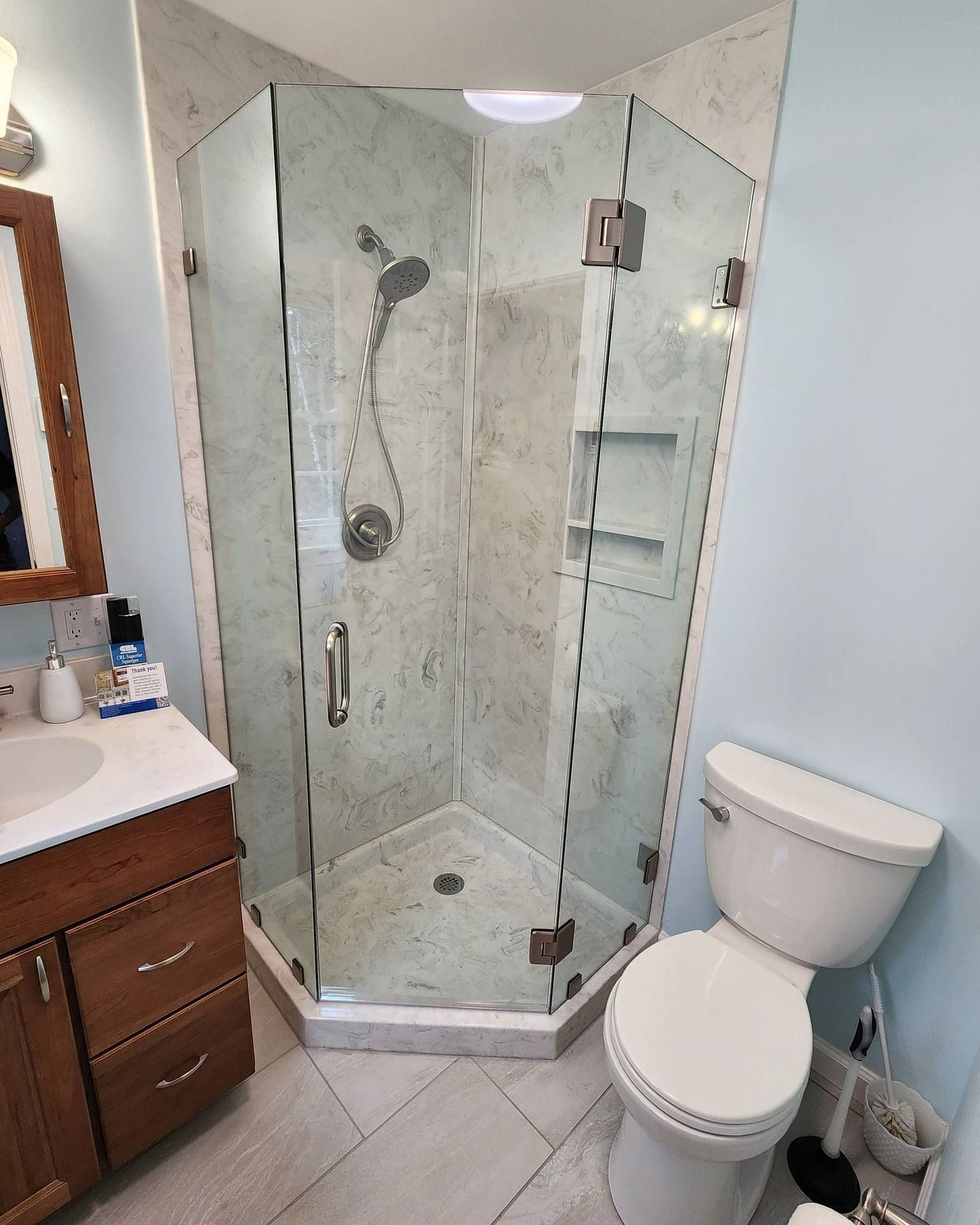 Bathroom with glass corner shower, vanity, and toilet