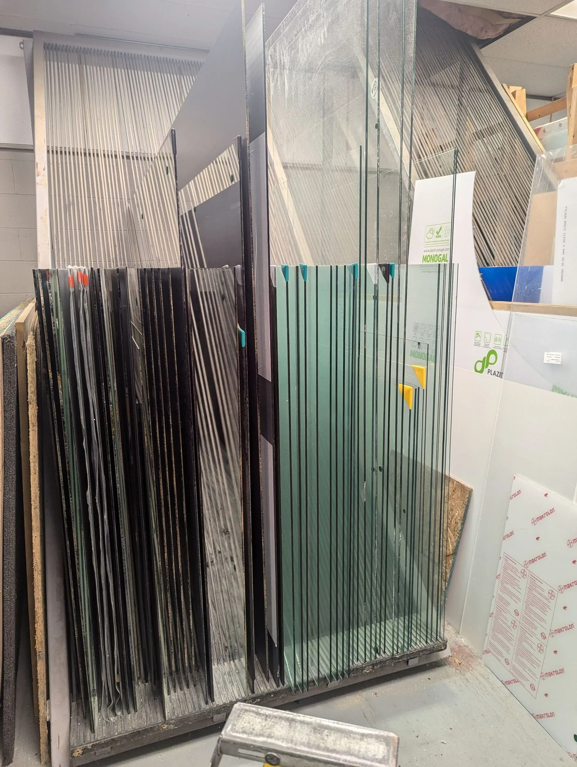 Hanging bundles of black, white, and green strands in a workshop, with papers on the wall.