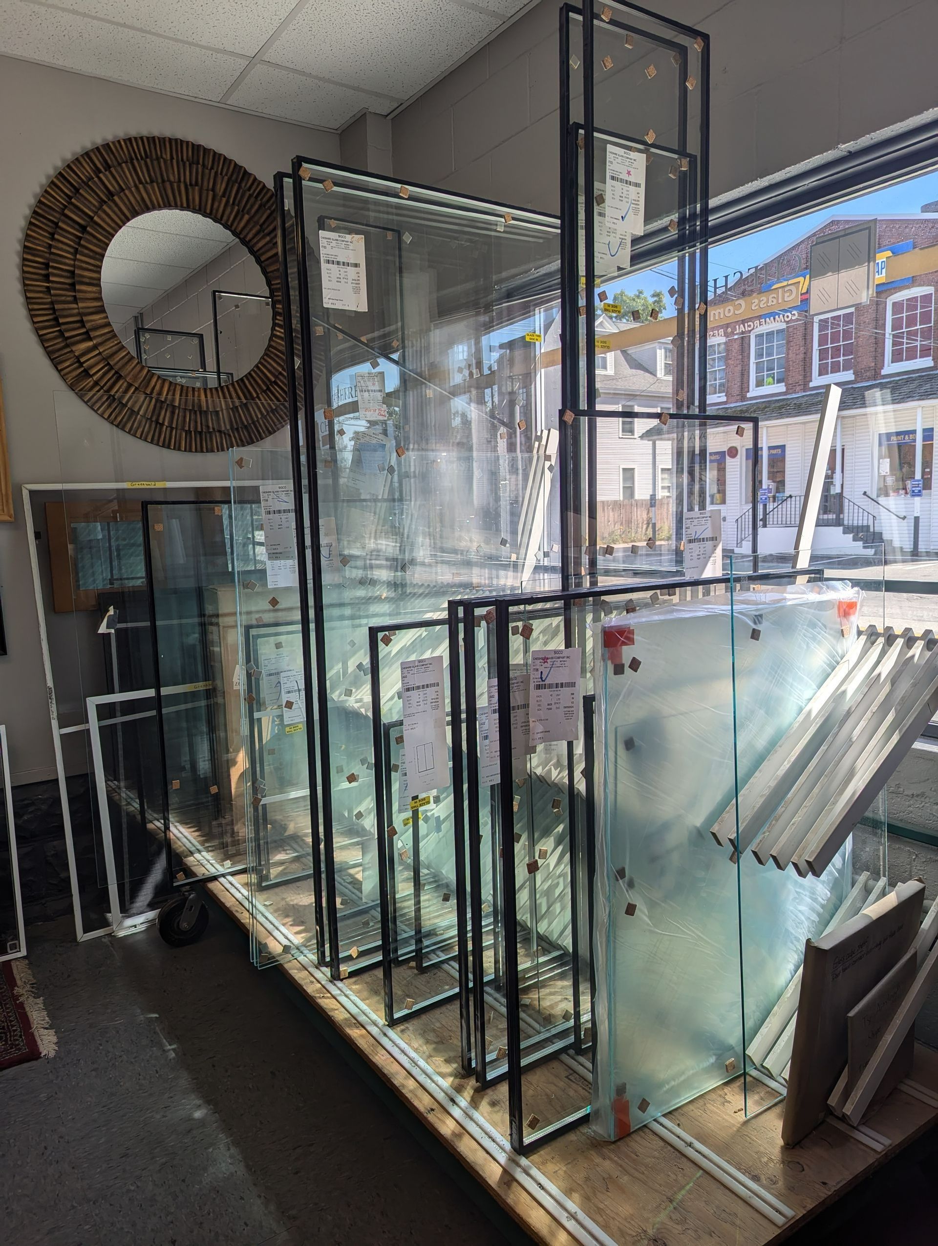 Glass display cases in a shop window, with a street and buildings visible outside.