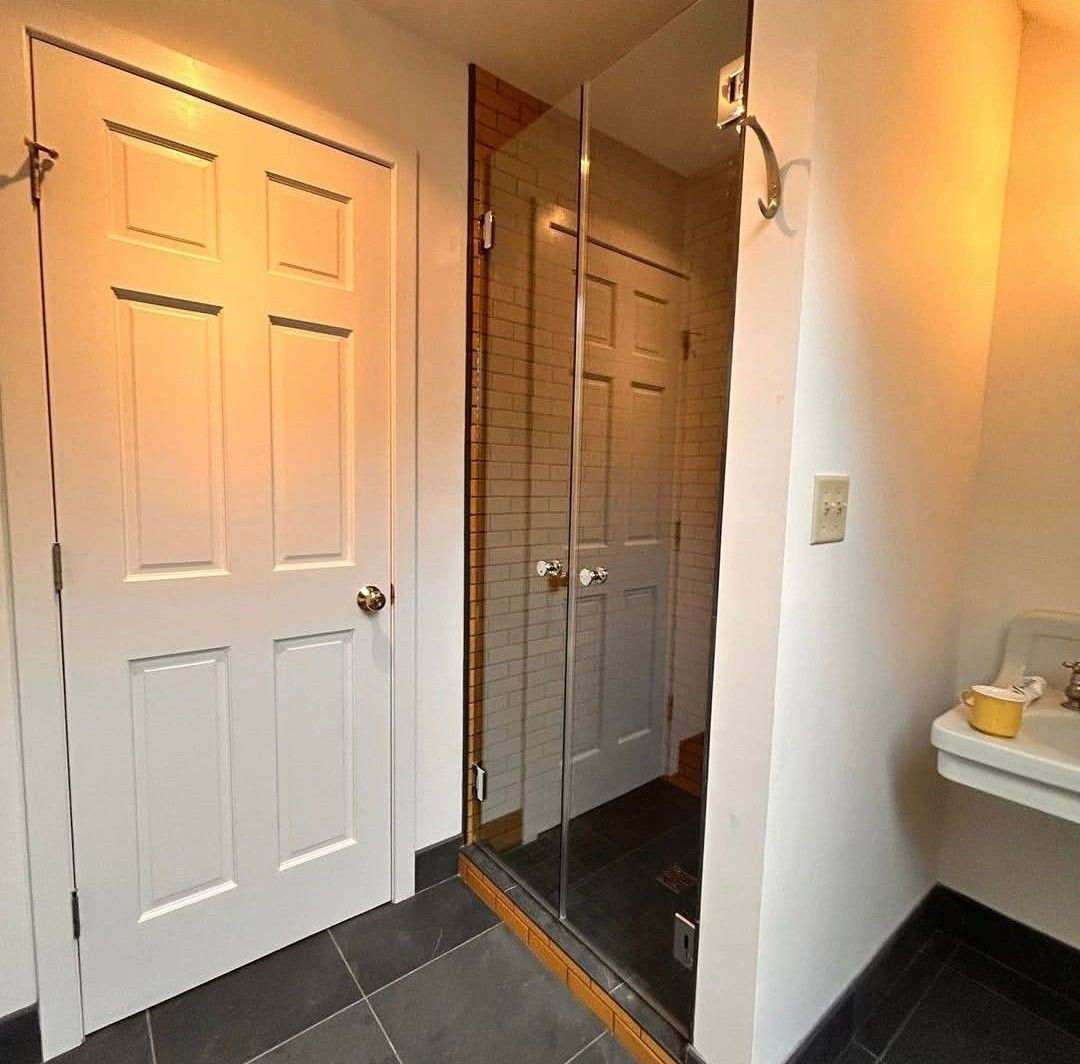 Hallway with white closet doors and mirrored sliding door, dark tile floor, and a small countertop at right