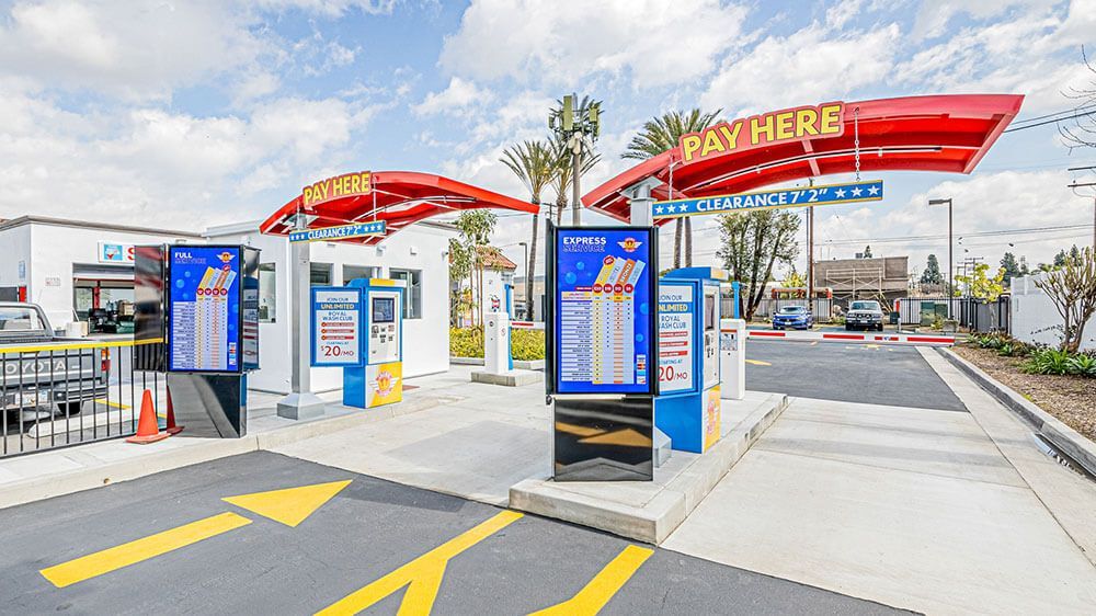 A car wash with a pay here sign on the top of it.