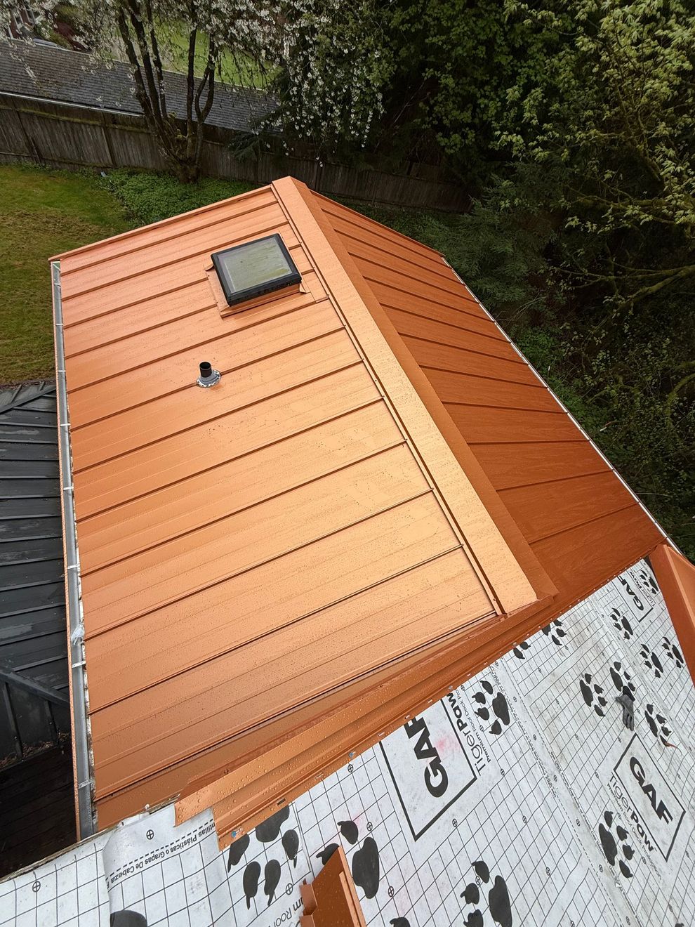 A copper roof with a skylight on top of it.