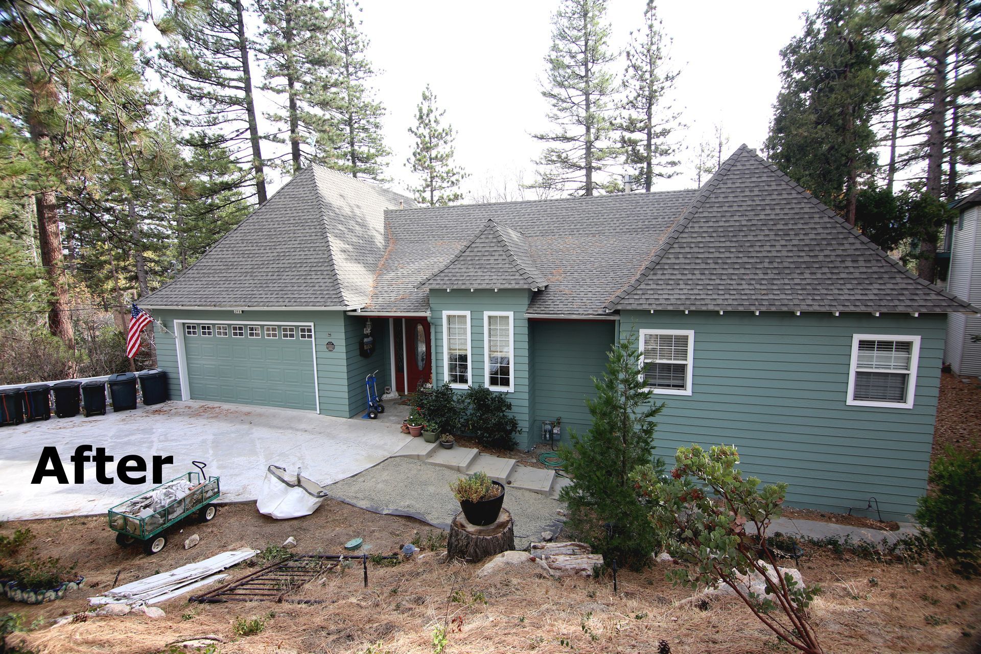 Green house with a shingled roof and a paved driveway, labeled 