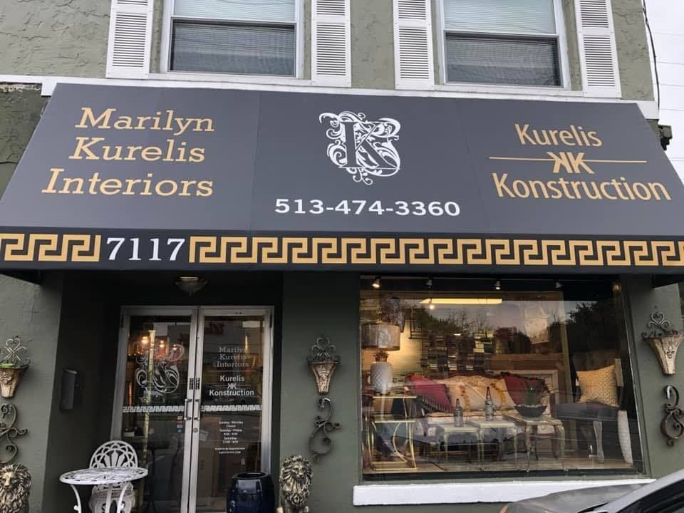 Marilyn Kurelis Interiors and Kurelis Construction storefront with dark awning and storefront window display