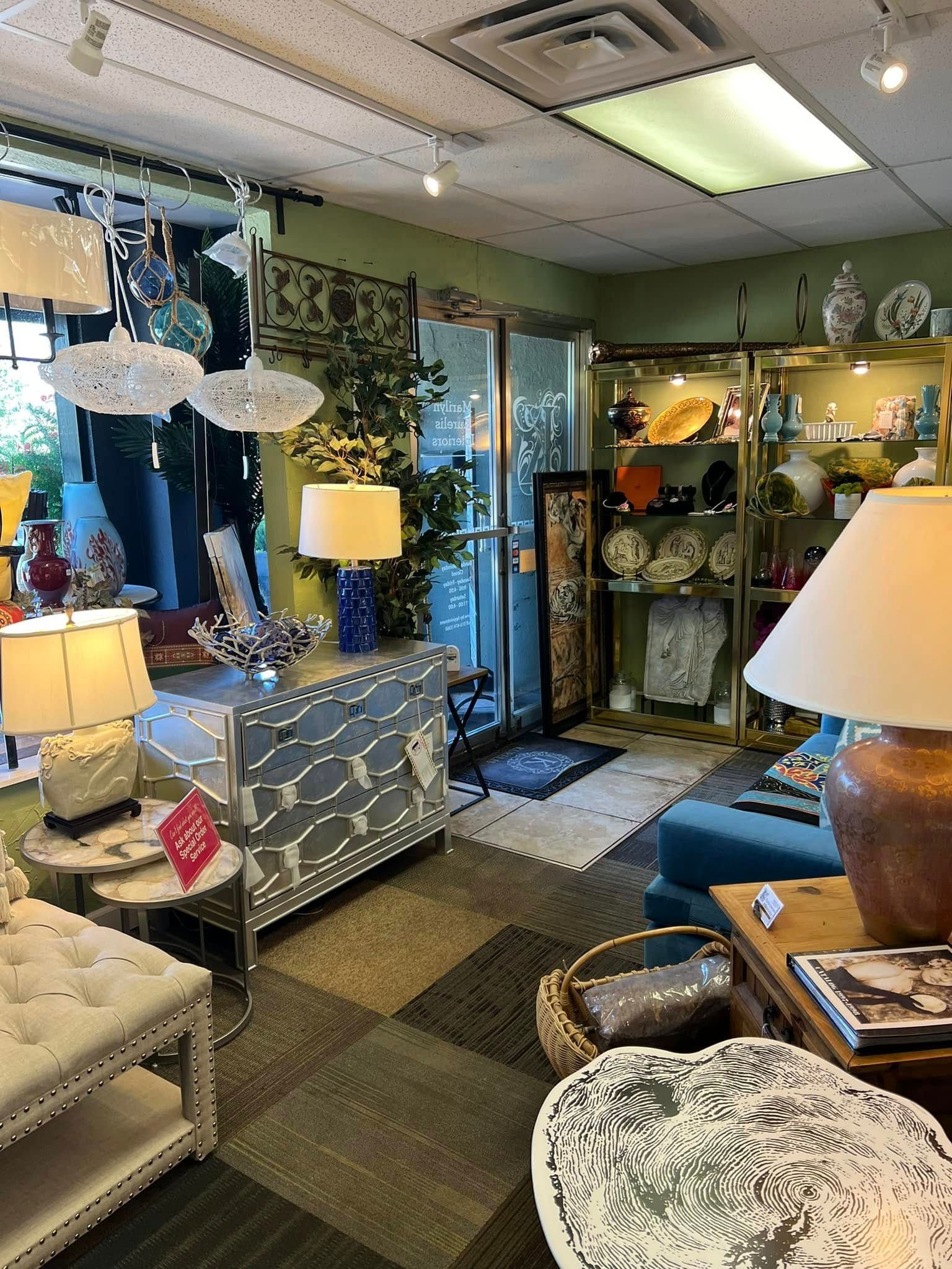 Eclectic home decor showroom with lamps, mirrors, shelves, and patterned furniture in a cozy display room