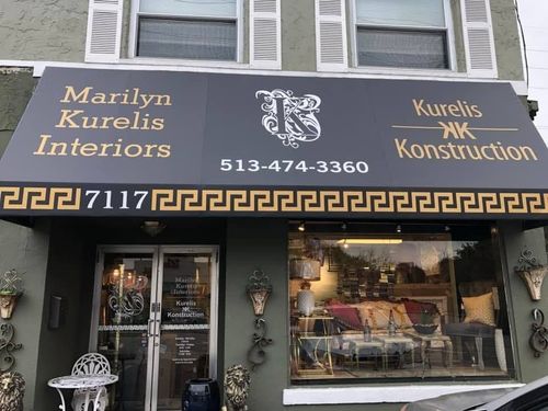 Storefront for Marilyn Kurelis Interiors and Kurelis Construction with awning, window display, and Greek key trim