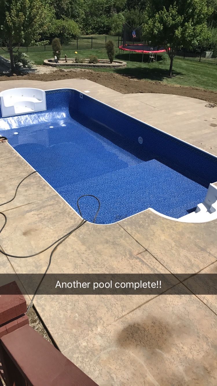 Finished rectangular swimming pool with blue speckled lining, concrete surround.