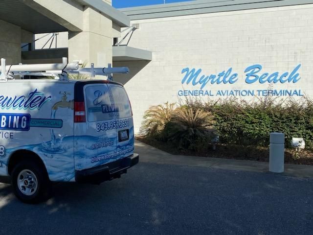 White van parked outside Myrtle Beach General Aviation Terminal.