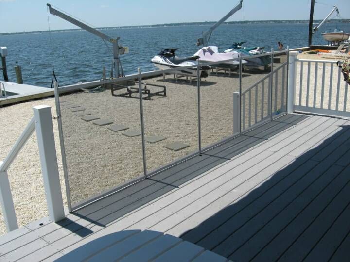 Dockside deck with railing overlooking the water, with jet skis in the background.