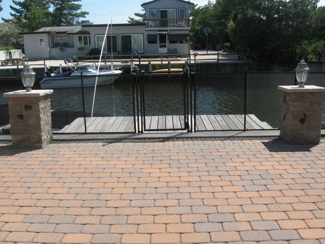 Dock gate over calm canal with houses and trees in the background