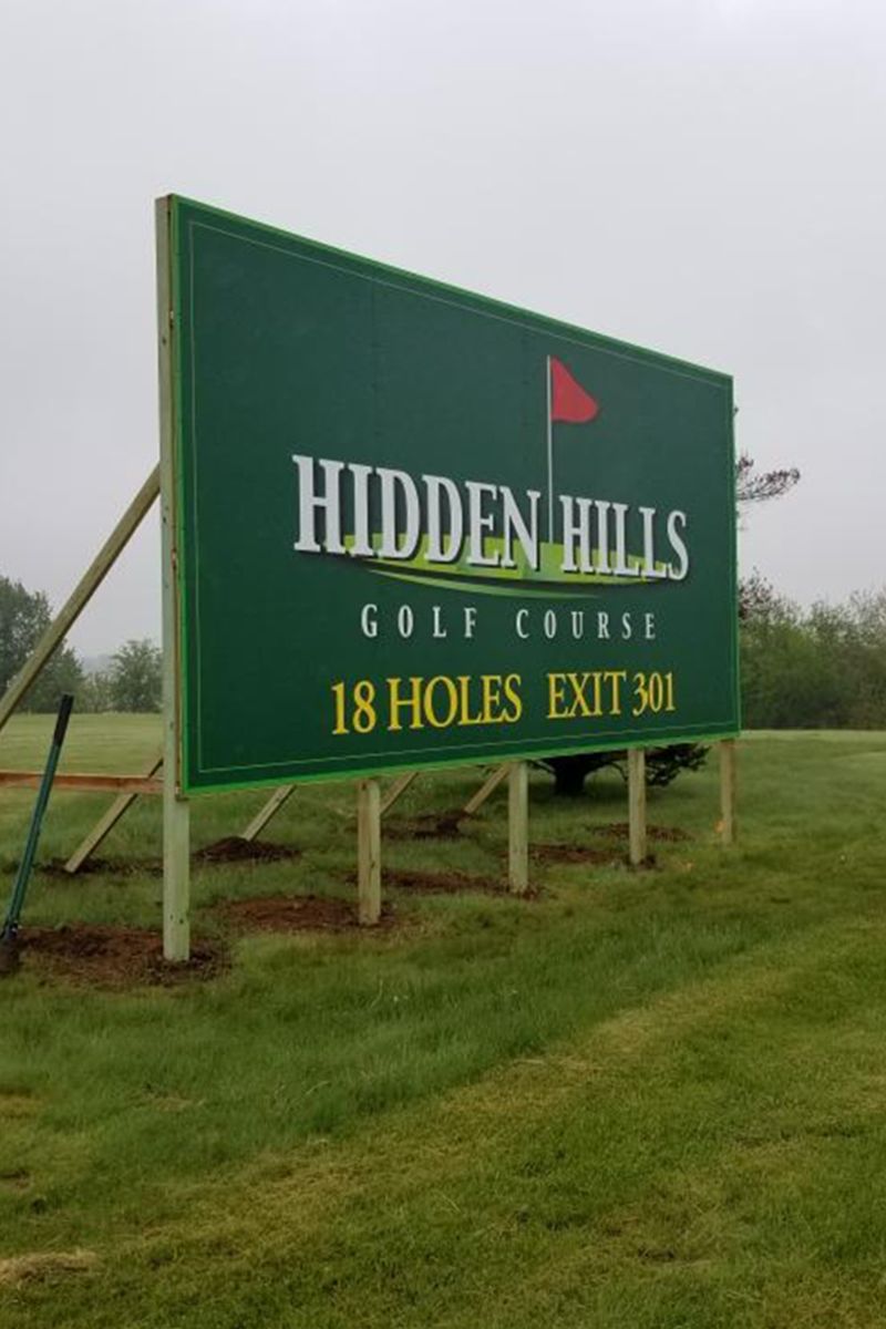 a large green billboard for hidden hills golf course