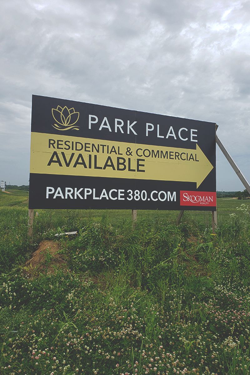 a sign in a field that says park place residential and commercial available