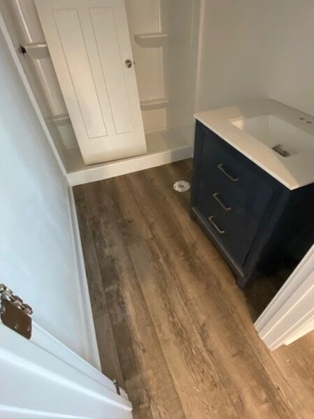a bathroom with hardwood floors and a sink